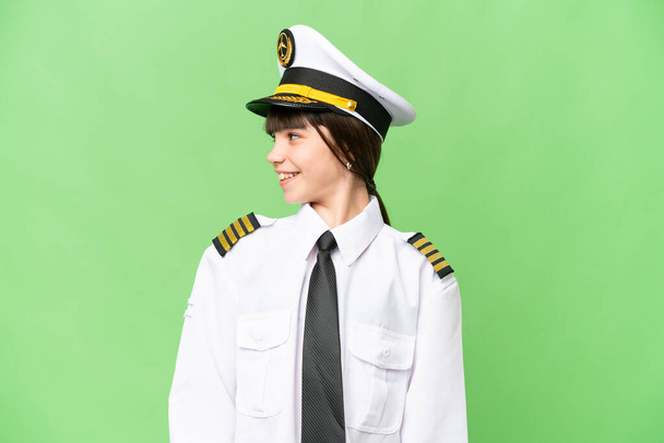 Malá dívka jako pilot letadla přes izolované chroma klíčové pozadí při pohledu straně - Fotografie, Obrázek