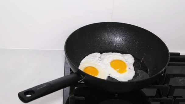 Tojásrántottát főzök reggelire. A tojást serpenyőben sütik, az étel fehérjében gazdag.. - Felvétel, videó