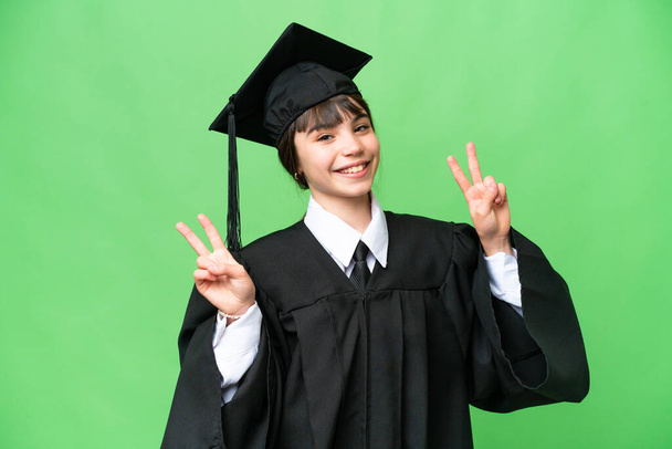 Little university girl over isolated background showing victory sign with both hands - Foto, Bild