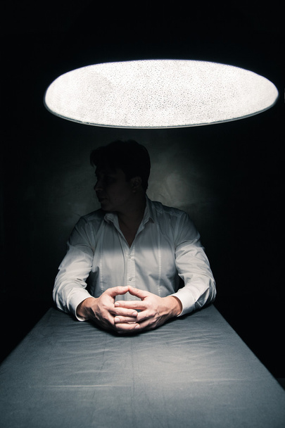 Man in a dark room illuminated only by lamp - Foto, Imagem