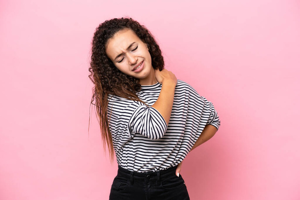 Giovane donna ispanica isolata su sfondo rosa che soffre di dolore alla spalla per aver fatto uno sforzo - Foto, immagini