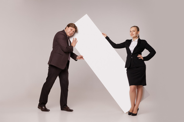 Homme d'affaires et femme debout sur une bannière vierge
 - Photo, image