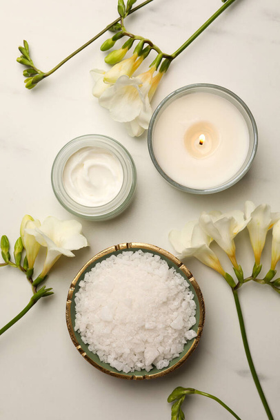 Flat lay composition with different spa products and flowers on white marble table - Foto, afbeelding