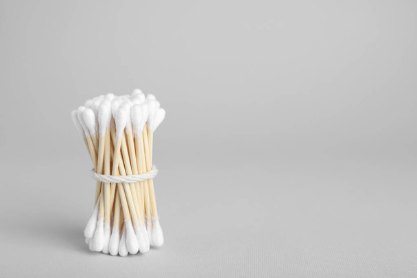 Bunch of wooden cotton buds on light grey background. Space for text - Foto, imagen