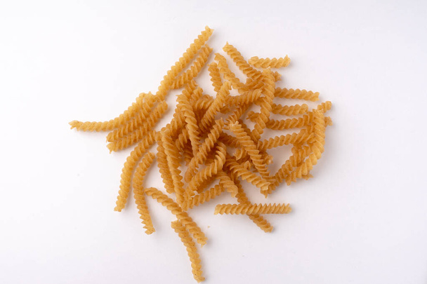 купа коричневих макаронних виробів фузілі ізольовані на білому
 - Фото, зображення