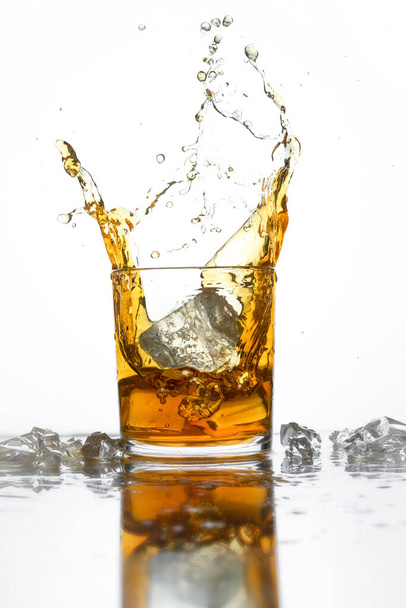 Splash of cola or whishky in a low glass isolated on a white background. selective focus. copy space - Photo, image
