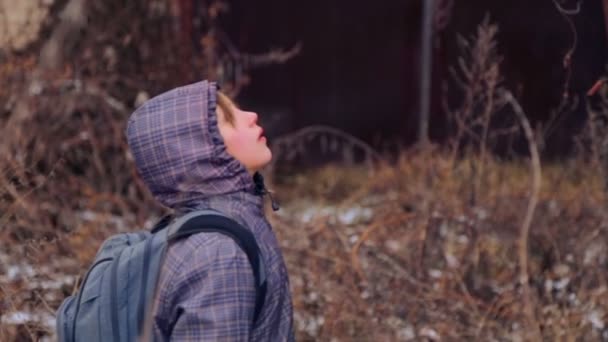Caucasian boy explores the old agricultural machinery. Child teenager on an abandoned farm in the winter. The old farm. Rusted farm equipment. - Imágenes, Vídeo
