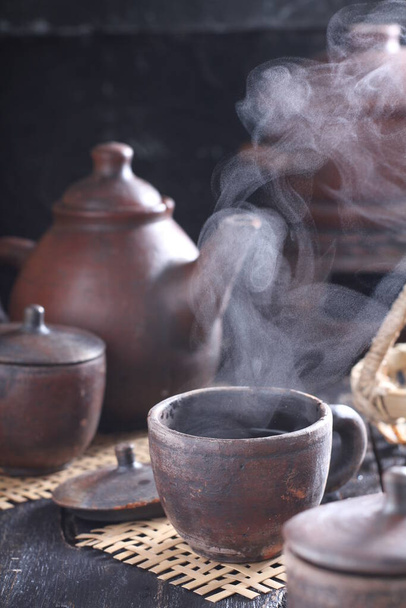 Tea is an aromatic beverage prepared by pouring hot or boiling water over cured or fresh leaves of Camellia sinensis, an evergreen shrub native to East Asia which probably originated in the borderlands of southwestern China and northern Myanmar.  - Fotoğraf, Görsel