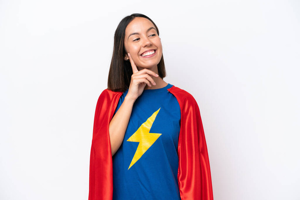 Super Hero caucasian woman isolated on white background thinking an idea while looking up - Photo, Image