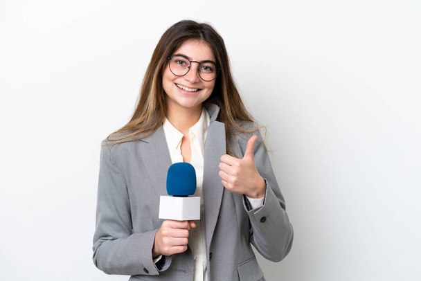 Junge kaukasische TV-Moderatorin isoliert auf weißem Hintergrund mit einer Daumen-nach-oben-Geste - Foto, Bild
