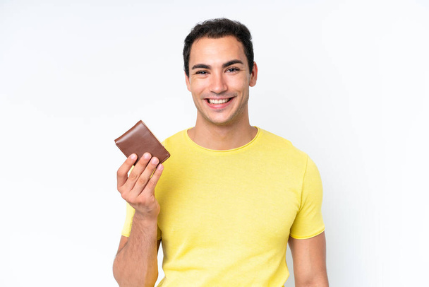 Young caucasian man holding a wallet isolated on white background smiling a lot - Φωτογραφία, εικόνα