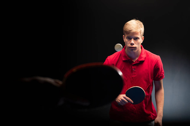 Portrét mladého muže hrající tenis na černém pozadí - Fotografie, Obrázek