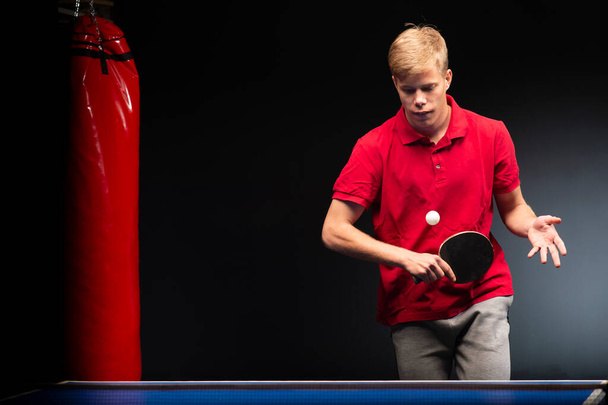 Portrait de jeune homme jouant au tennis sur fond noir - Photo, image