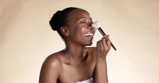 Kasvot, nenä ja punastua malli musta nainen studiossa ruskealla taustalla soveltaa meikkiä. Kosmetiikka, leikkisä ja poskipuna houkutteleva nuori nainen soveltamalla tuote kauneutta iholleen. - Materiaali, video