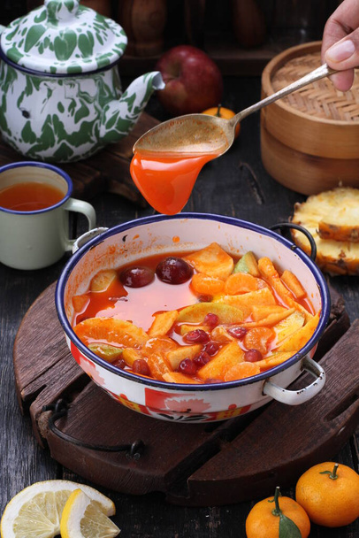 Asinan ist ein eingelegte Gemüse- oder Obstspeise, die häufig in Indonesien zu finden ist. Asin, indonesisch für "salzig", ist der Prozess, die Zutaten zu konservieren, indem man sie in eine Lösung aus salzigem Wasser tränkt. Asinan ist dem Rujak sehr ähnlich., - Foto, Bild