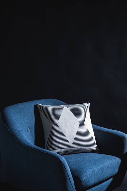 sisustus ja sisustus konsepti - lähikuva sininen tuoli tyyny musta seinä - Valokuva, kuva