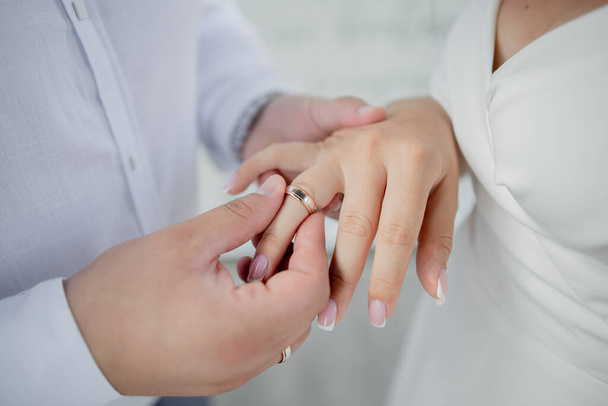 a bride and groom exchange wedding rings on their hands - Fotografie, Obrázek