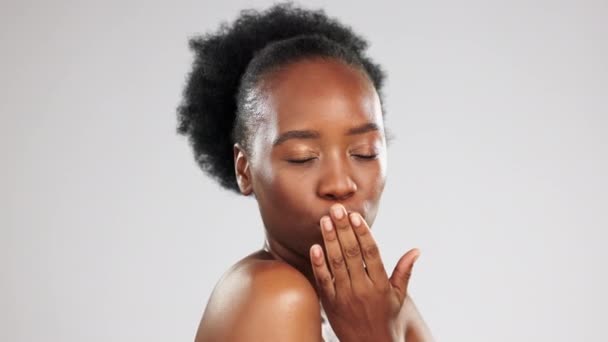 Skincare, face and black woman blowing kiss in studio isolated on a gray background. Portrait, makeup cosmetics and laughing female model blow air kisses for self love, romantic smile and beauty - Footage, Video