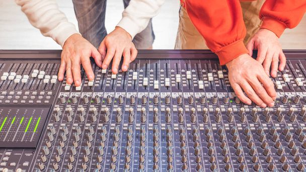 four sound engineer hands working on audio mixing console. recording, broadcasting, live concept - Fotoğraf, Görsel