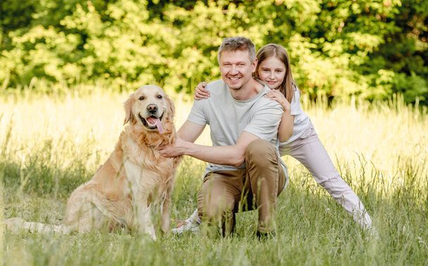 Dad and his daugter play with golden retriver dog - Фото, изображение