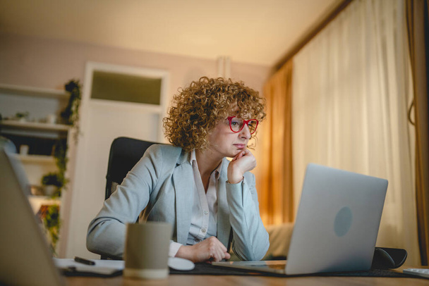 Eine Frau kaukasischen weiblichen Arbeit, während am Schreibtisch sitzen Laptop verwenden Unternehmerin oder Managerin Anwalt arbeiten in der Nacht zuversichtlich Vorbereitung Strategie und machen Plan echte Menschen kopieren Raum - Foto, Bild