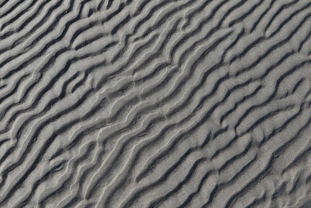 Irregular deep ripples in some wet sand - Foto, afbeelding