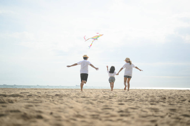 Szczęśliwa azjatycka rodzina podróżuje razem na plaży na wakacje. Rodzina podróżująca po plaży. Ludzie cieszący się wakacjami. Wysokiej jakości zdjęcie - Zdjęcie, obraz