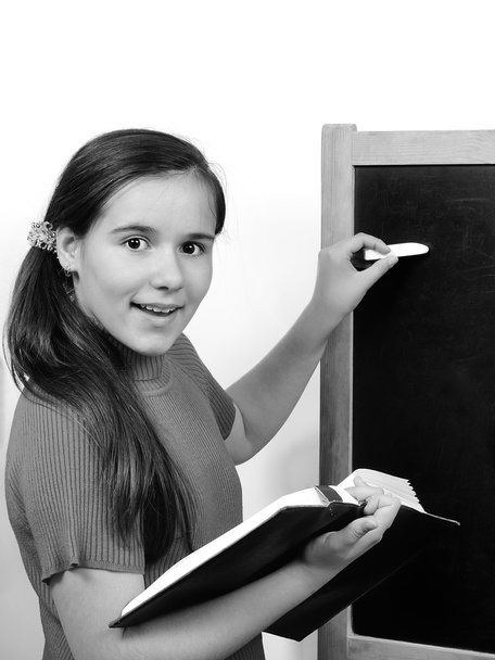 Девочка-подросток ученица пишет на доске мелом урок
 - Фото, изображение