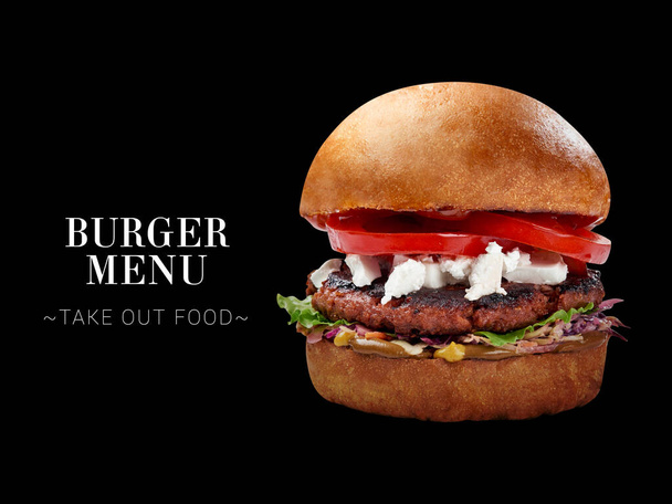 Veggie burger with meat-free cutlet, Feta cheese, tomatoes, lettuce, bbq sauce. burger isolated on black background. Ready menu sandwich advertising banner with text and copy space - Foto, Imagen