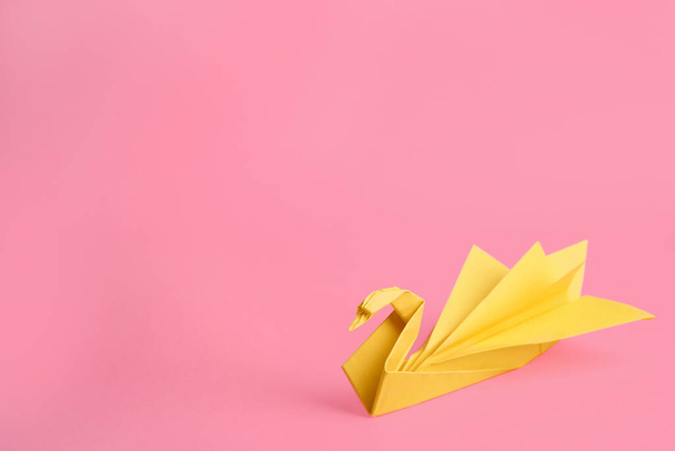 Origami art. Beautiful paper swan on pink background, space for text - Фото, изображение