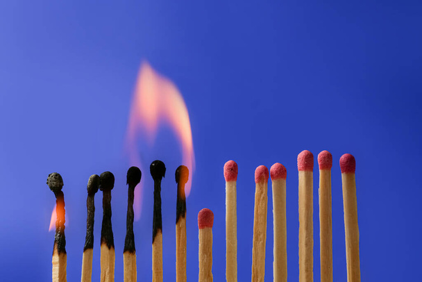 Burning and whole matches on blue background. Stop destruction concept - Photo, Image