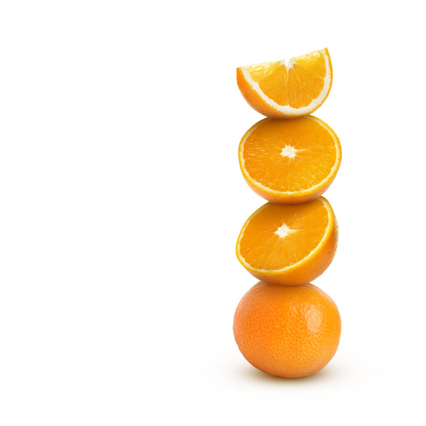 Stacked cut and whole oranges on white background - Photo, image