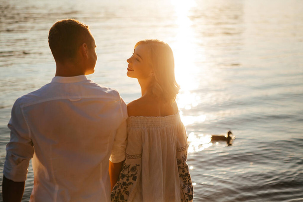 Young couple at sunset by the water - Foto, Bild