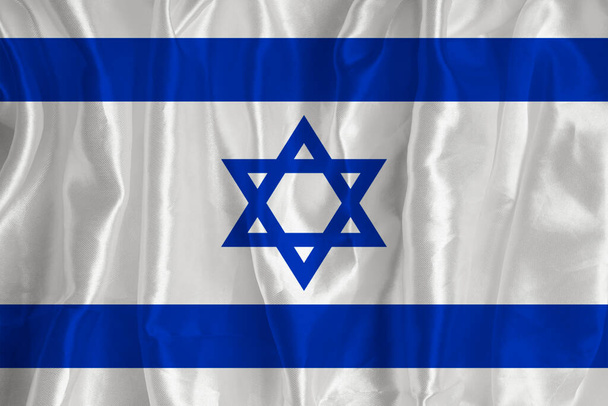 The Israeli flag on a silk background is a great national symbol. Fabric texture The official state symbol of the country. - Foto, Imagen