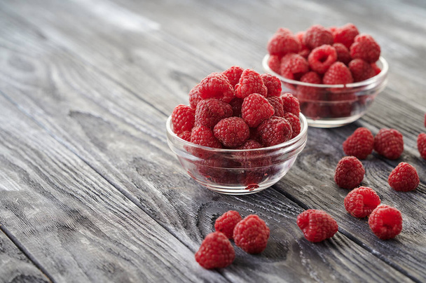 Red ripe raspberries, berries in plates on the table, shot close-up - Foto, Imagen