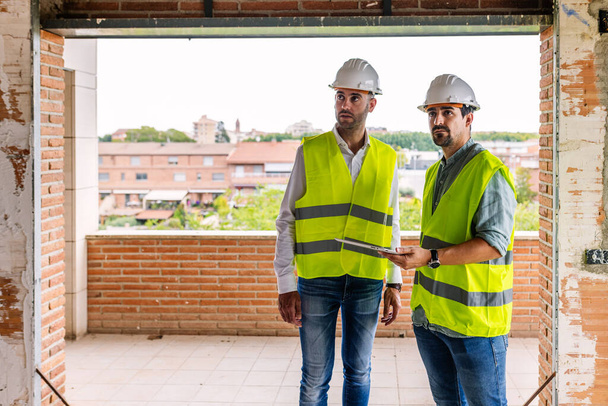 Male architects discussing about construction building site process interior. - Fotó, kép