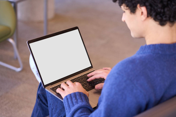 Overhead view of a man, developer programmer using laptop with white blank screen with free ad space for mobile applications. Smart guy writing programs, typing text on keyboard. People and Technology - Photo, image