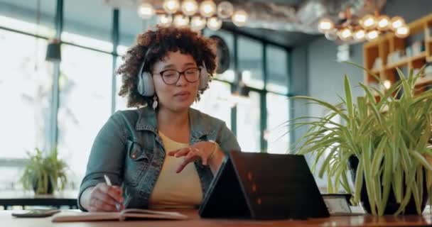 Tablet, videogesprek en praten met een zwarte vrouw in een koffieshop voor werk of communicatie op afstand. Virtuele ontmoeting, notitieboekje en planning met een jonge vrouwelijke freelance medewerker die in een café werkt. - Video