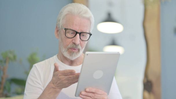 Portrait of Senior Old Man Doing Video Chat on Tablet - Foto, afbeelding