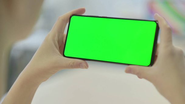 Mujer sosteniendo Smartphone con pantalla verde - Foto, Imagen