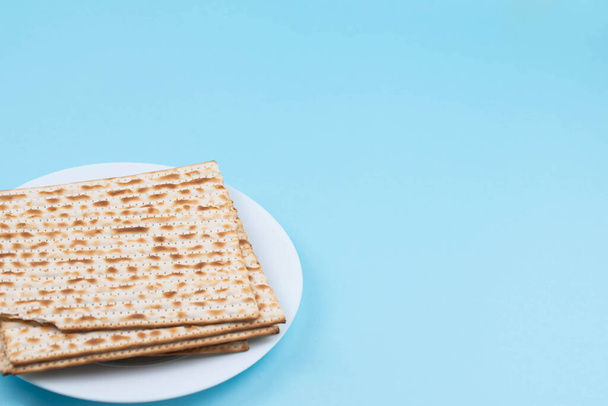 Matzah on the plate on blue background. Pesah Passover holiday celebration dinner concept. - Foto, afbeelding