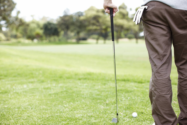 Измеряю расстояние впереди. Обрезанный вид на человека, играющего в гольф на поле - Фото, изображение