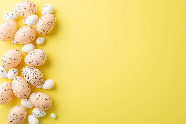 Easter decorations concept. Top view photo of easter quail eggs on isolated yellow background with empty space - 写真・画像