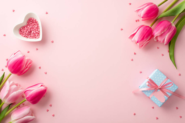 Women's Day concept. Top view photo of tulips heart shaped saucer with sprinkles and small blue giftbox on isolated pastel pink background with copyspace - Photo, Image