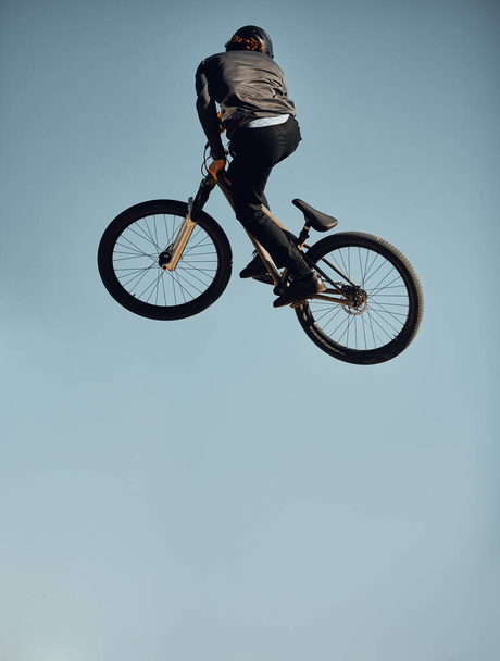 Велосипед, велосипед і чоловік роблять трюк стрибків неба для змагань зі спортивного вільного стилю, ігор або подорожей. Повітряний макет, енергія і гірський велосипед людина робить вправи, тренування або веселі тренування з фітнесу
. - Фото, зображення