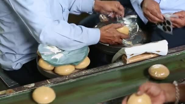 Nahaufnahme von Arbeitern, die während der Produktion eine halbautomatische Seifenwickelmaschine in der Seifenfabrik benutzen - Filmmaterial, Video
