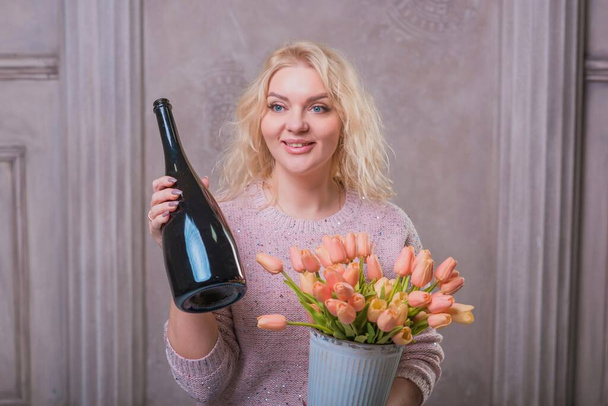 Nice happy woman celebrate with bottle of Champaign and flowers. Happy mood - Φωτογραφία, εικόνα