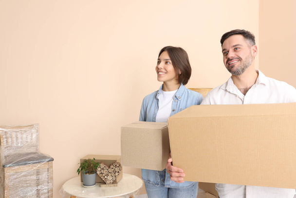 Happy couple with moving boxes in new apartment - Φωτογραφία, εικόνα
