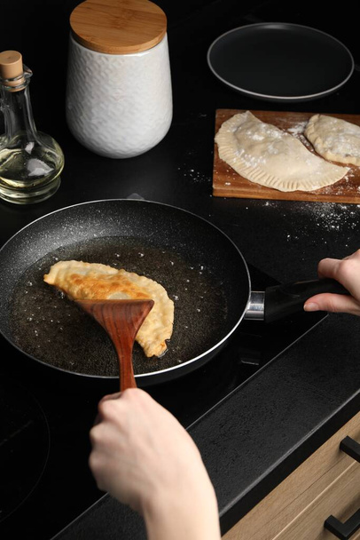 Woman cooking chebureki in frying pan, closeup - Foto, imagen