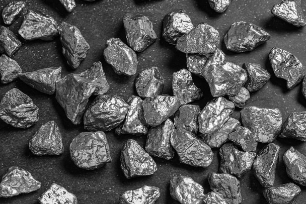 Many silver nuggets on black table, above view - Фото, зображення